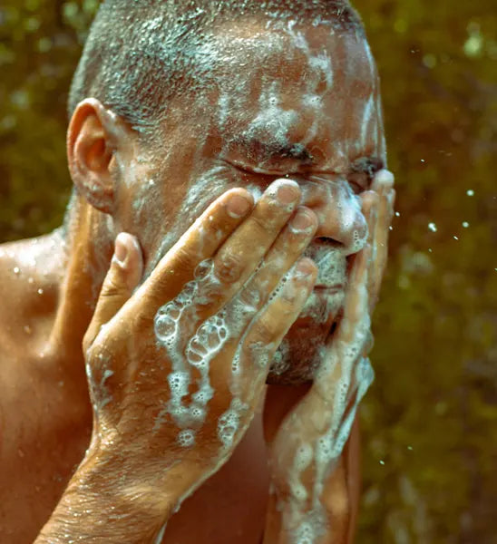 Man washing his face with Black Lava Clay Soap By Valenti Organics