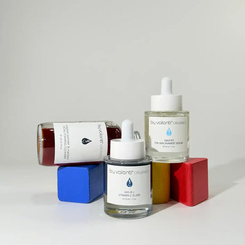 BY VALENTI brightening set with three products foaming cleanser, and two serums in glass bottles over white background