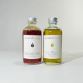 Two bottles of BY VALENTI organics facial cleansing products on a white background