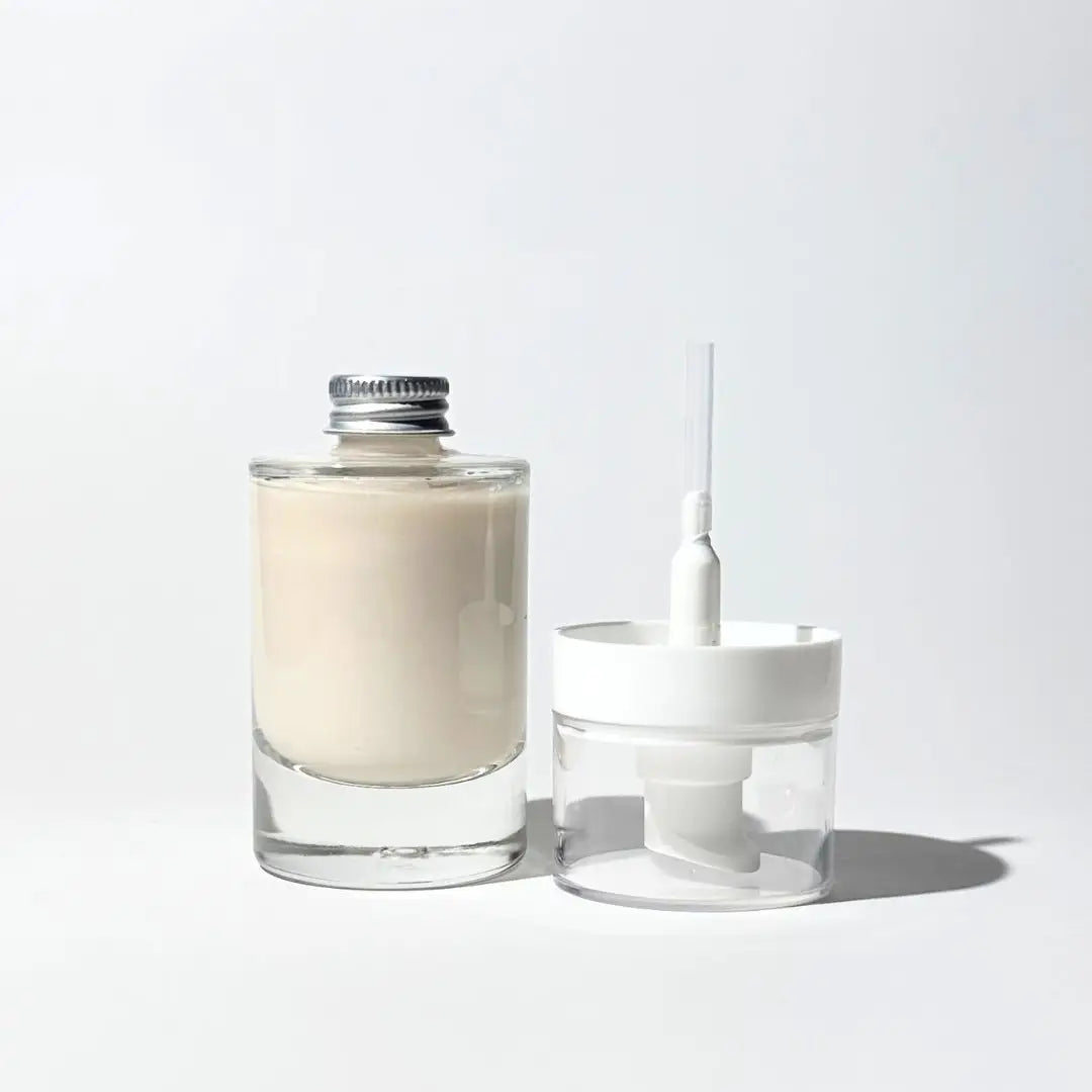 By Valenti returnable and refillable clear glass of Lavender & Lemongrass Antiaging Facial Lotion with aluminium cap and a reusable lotion pump on a white background.